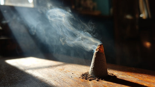 Close-up of incense cone releasing smoke in a sunbeam, symbolizing indoor air quality and fragrance effects.