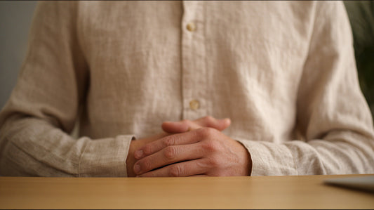 Close-up of hands resting gently on a desk in a calm, mindful posture, symbolizing stillness and awareness at work.