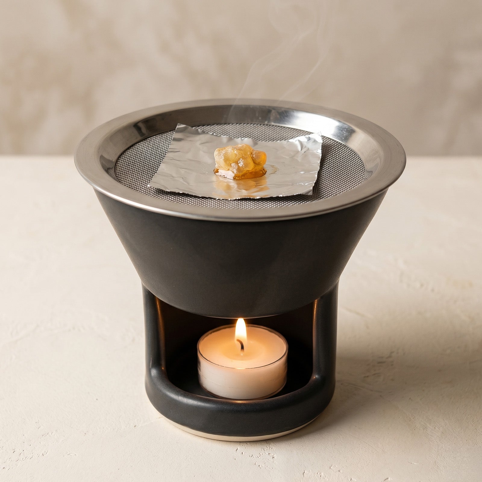 Resin incense warming on foil over a ceramic incense warmer