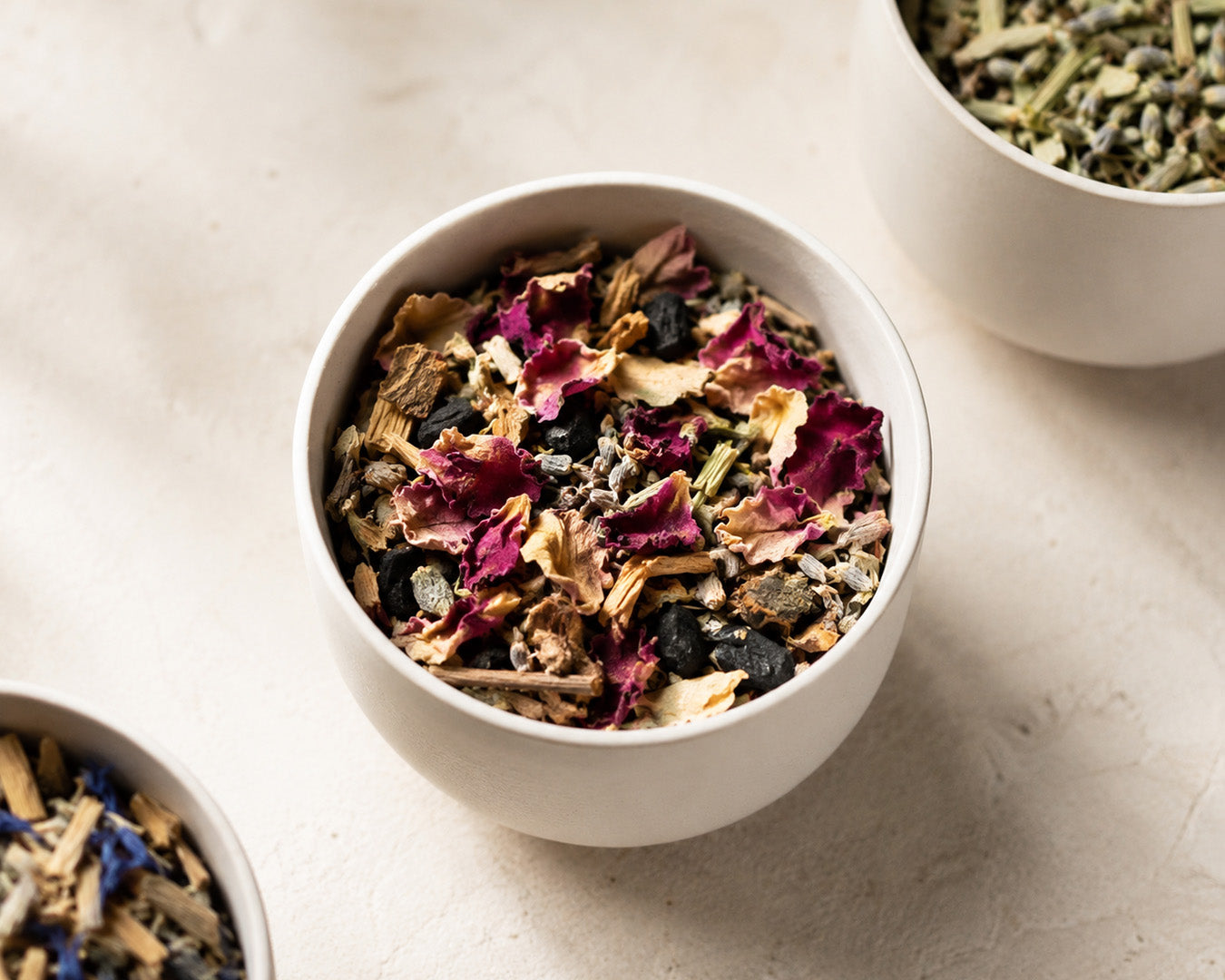 Bowl of loose botanical incense with rose petals, wood, and botanicals