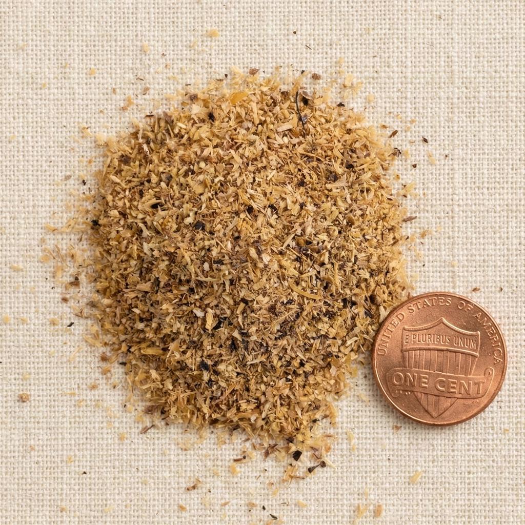 Palo Santo powder beside a penny for particle-size reference