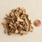 Palo Santo wood chips beside a penny for size reference