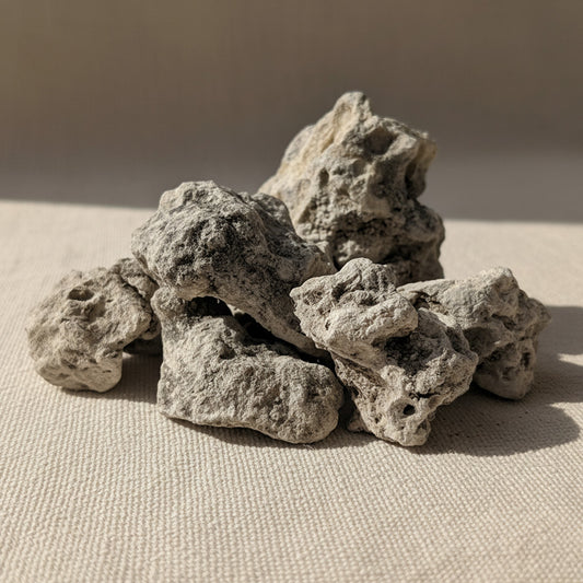 Natural Breu Copal resin pieces from the Amazon rainforest shown on a soft linen background, highlighting their pale, chalky surface and organic texture.