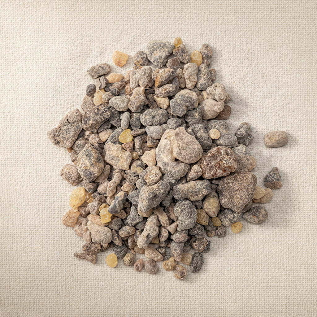 Natural Boswellia Rivae resin pieces showing warm brown and golden tones, photographed under soft light on linen.